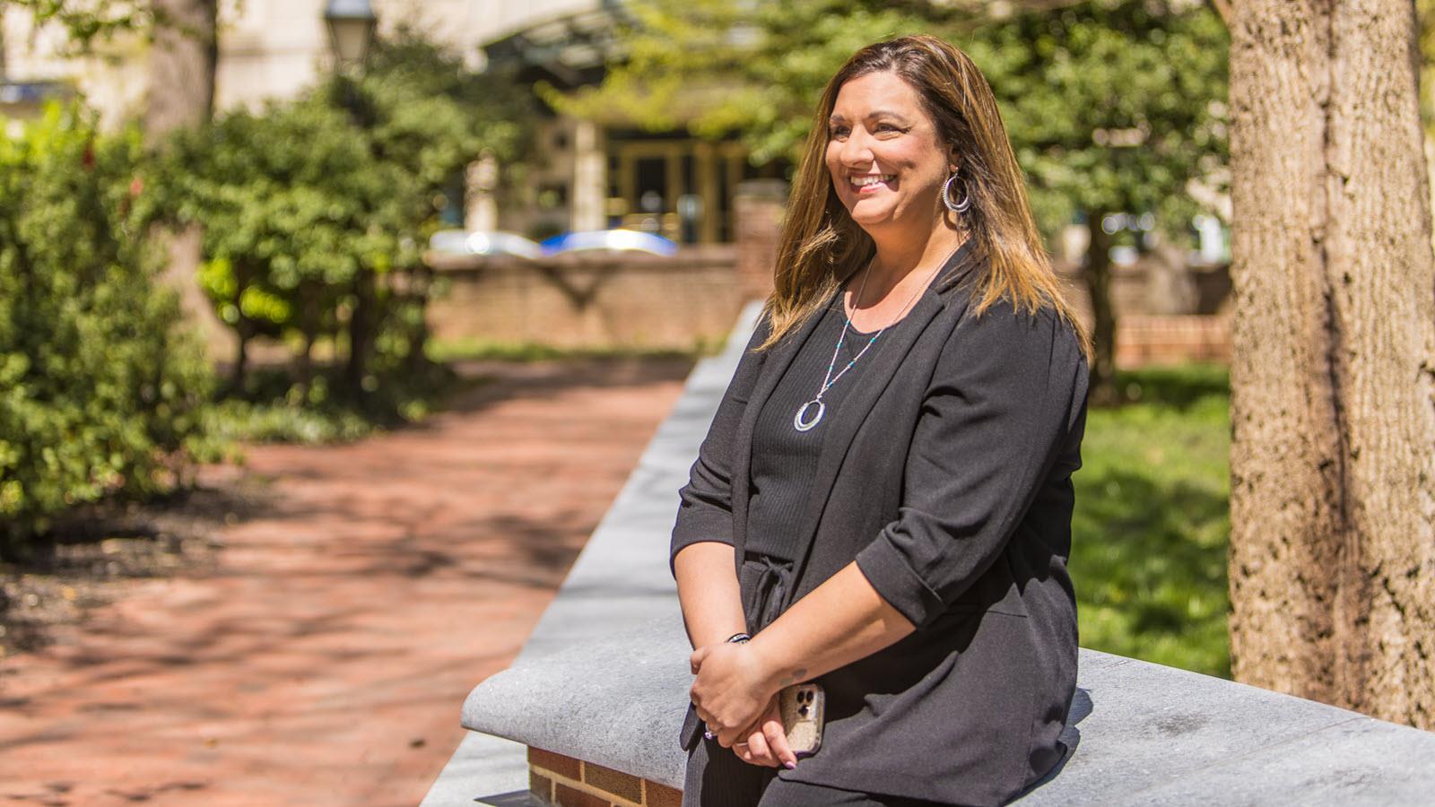 Krissy, mom to a son who has hemophilia, outdoors on a bench