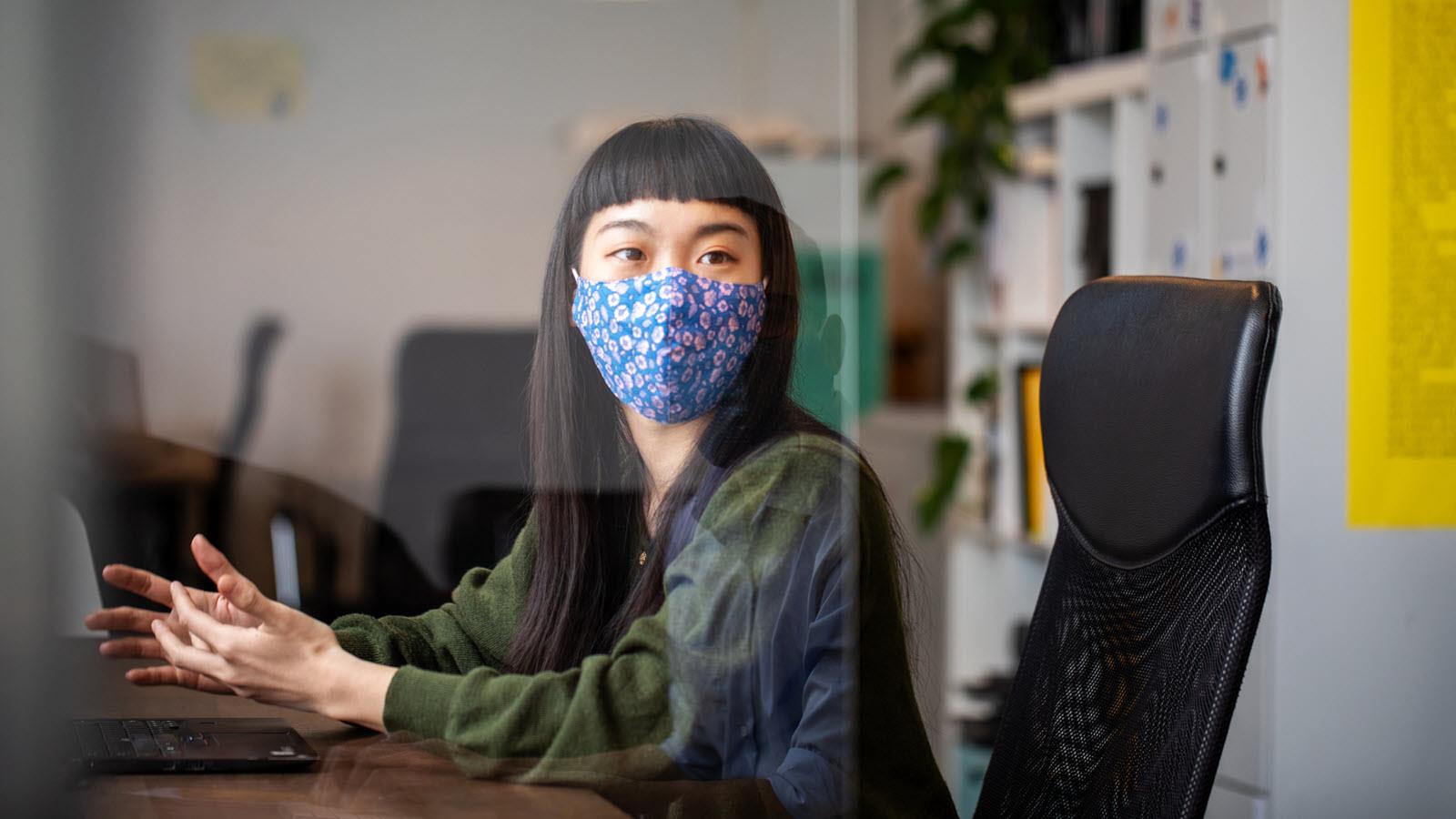 Woman wearing a face mask at her desk at work