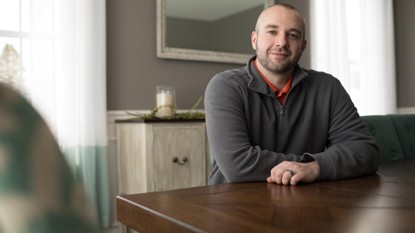 Hemophilia patient, Pete, seated at a table.