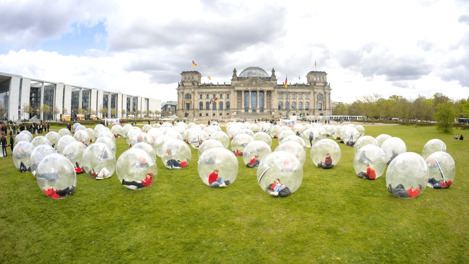A World PI Week demonstration of 100 people in plastic bubbles in front of a government building in Berlin, Germany.
