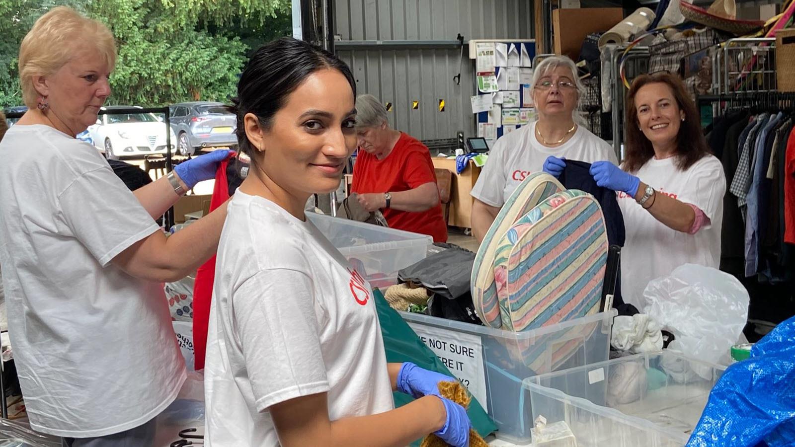 CSL Behring employees sort clothes for a resale shop.
