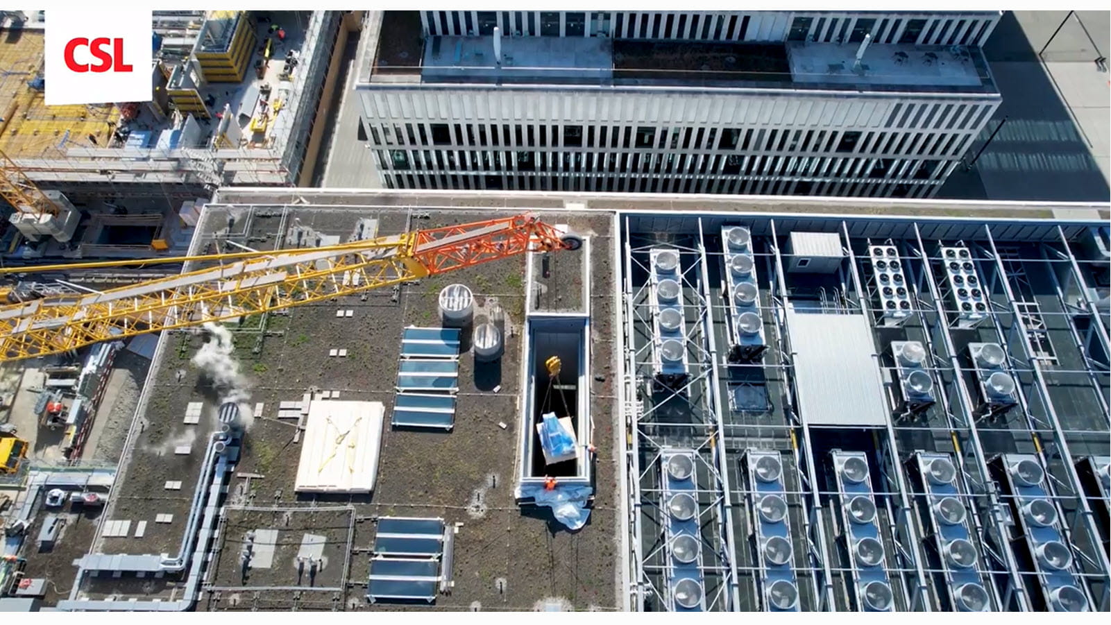 A construction crane drops equipment into a hole in the roof of CSL Behring's facility in Bern, Switzerland