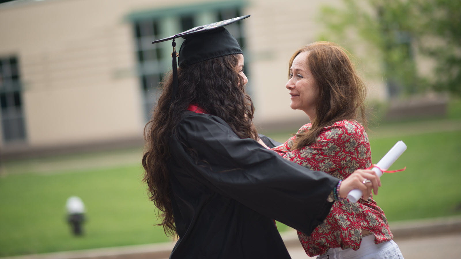Young woman celebrates her graduation with her mother.