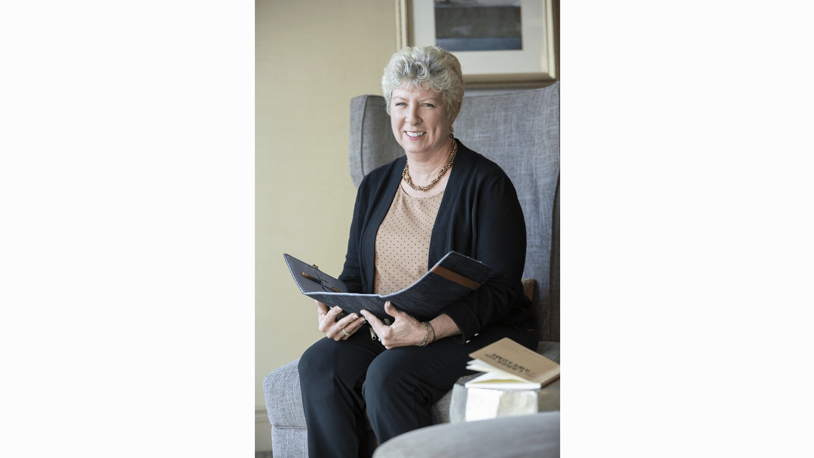 Dee, an Alpha-1 Antitrypsin Deficiency patient, sitting with a book in her lap