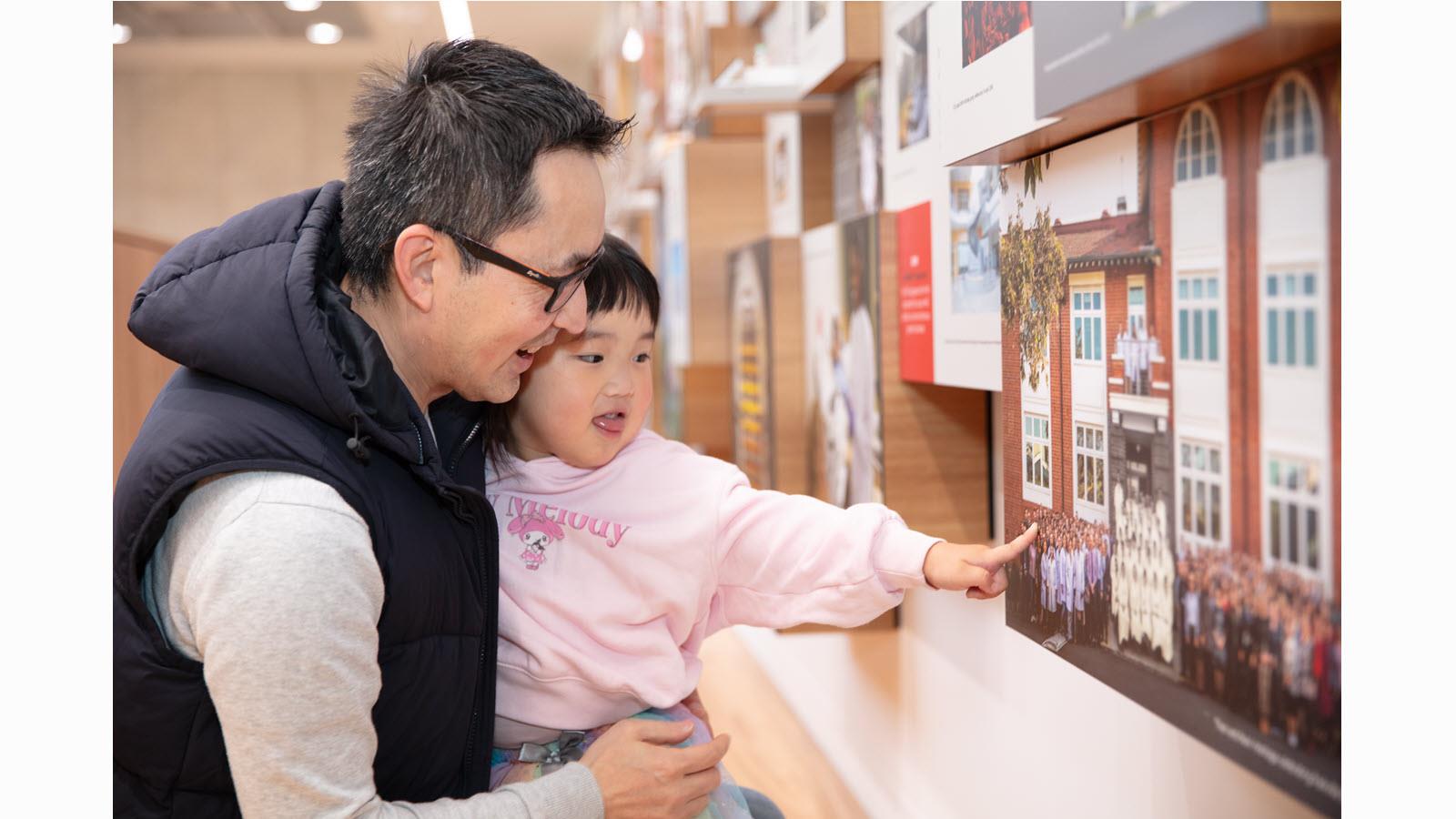 A child points to a wall display at CSL's Friends & Family Day.