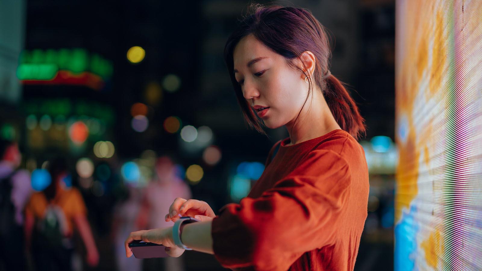 woman looks at smartwatch