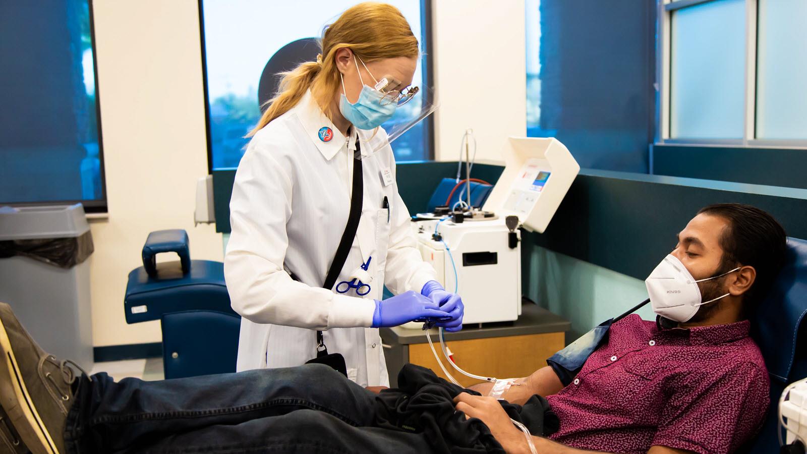 Man wears mask while donating plasma during the pandemic